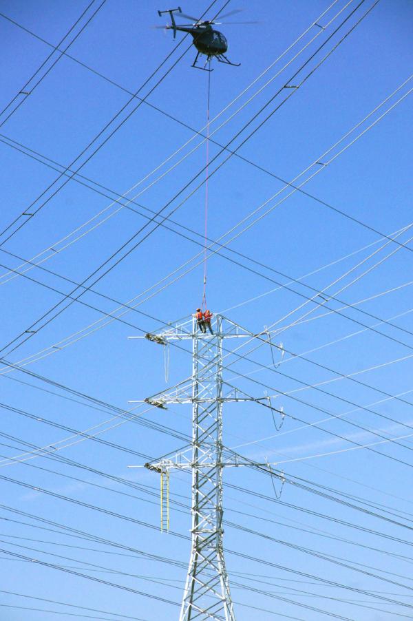 Helicopter skillfully lifts workmen off PG&E tower