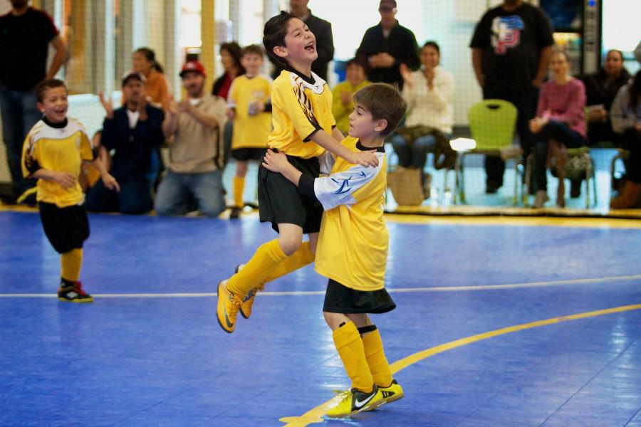 Victory! Teammates celebrate indoor soccer win.