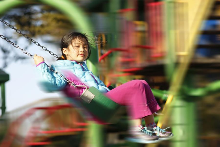 A little girl is enjoying the swing