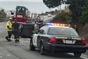 First responders attend to safety and question occupants of a vehicle rollover on Highway 1.