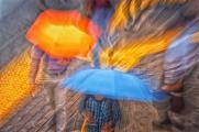 Umbrellas and pedestrians-a raindrops view.