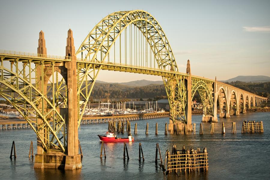 A fishing trawler returning to port and passing beneath Yaquina Bay Bridge, Newport, Oregon.