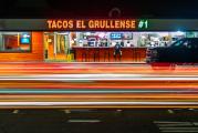 Cars in a hurry stream past a Redwood City taqueria