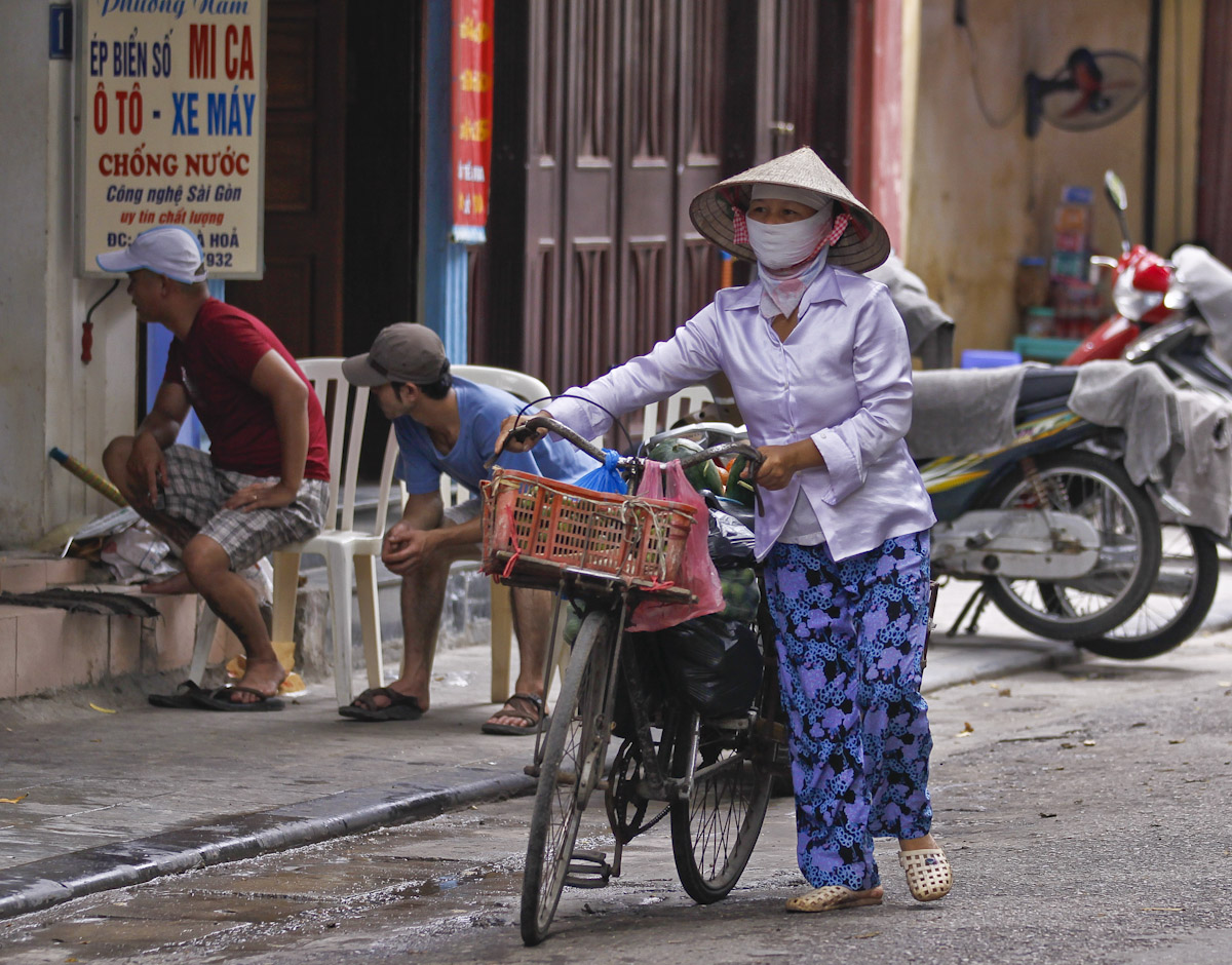 A Local Merchant transporting her goods on a bike, Hanoi, Vietnam