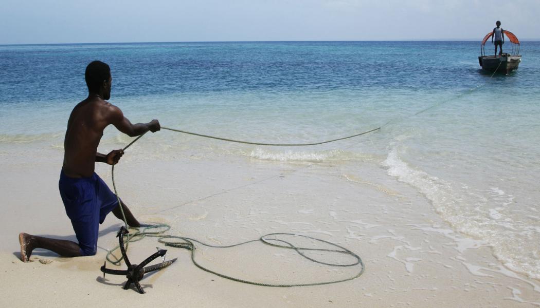 Fisherman pulling in the boat on the beach of Zanzibar