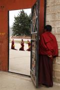 A monk peeping to see others reciting bible with hand gestures